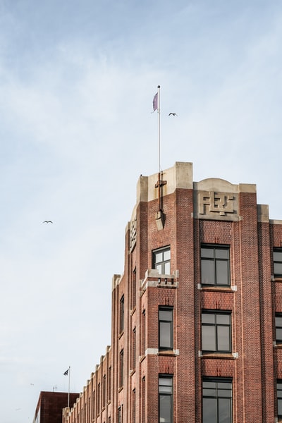 顶部有白旗的棕色混凝土建筑
